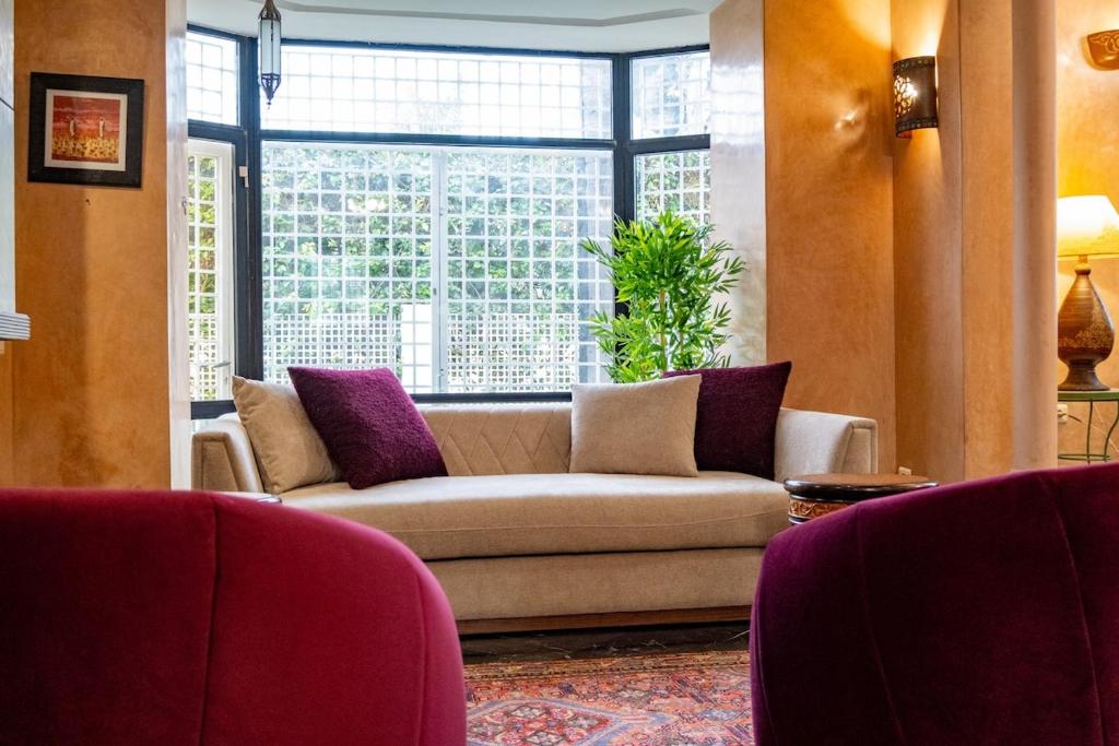 a living room with a couch and a window at Villa BALRA une maison d'hôtes au coeur du centre ville in Rabat