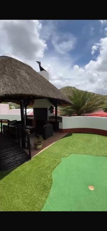 a resort with a putting green in front of a building at Tourmaline GuestHouse in Windhoek