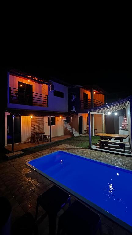 a pool table in front of a house at night at Chalés Boqueirão beach in Japaratinga