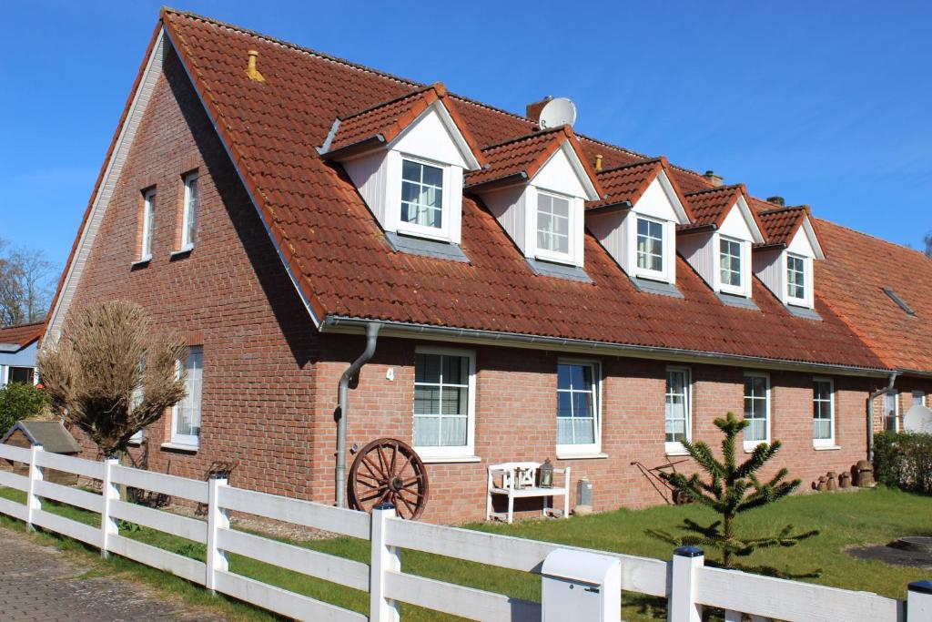 a large brick building with a red roof at Landhaus Behrenwalde in Weitenhagen