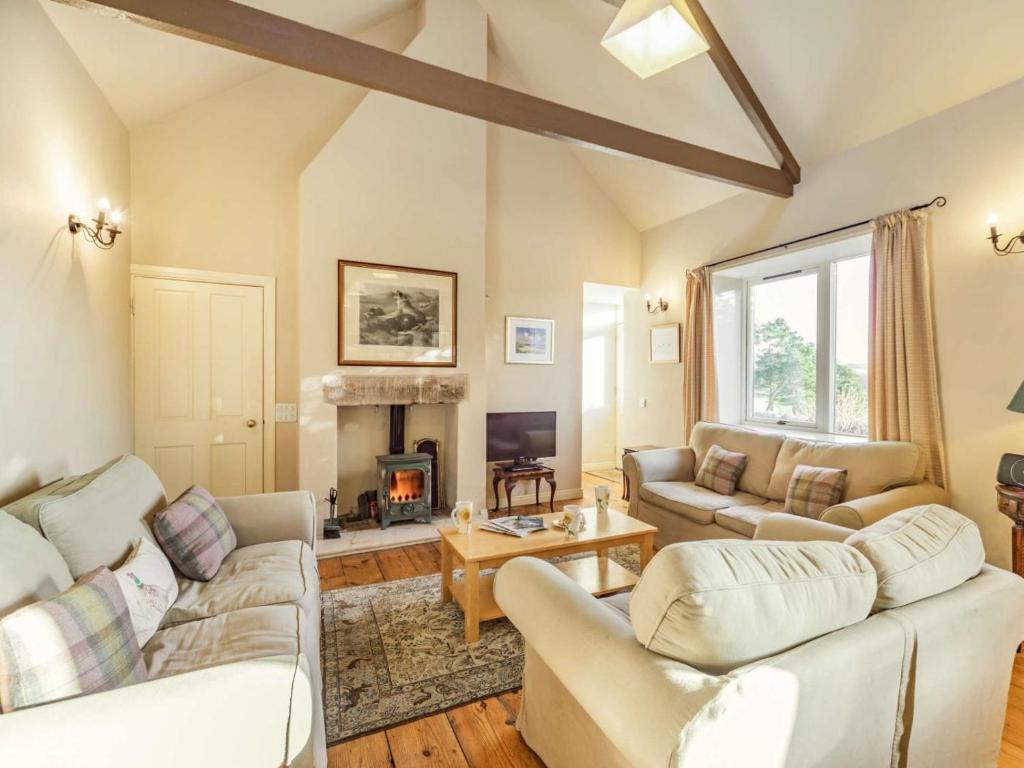 a living room with two couches and a fireplace at 4 Bed in Mindrum oc-86272 in Carham