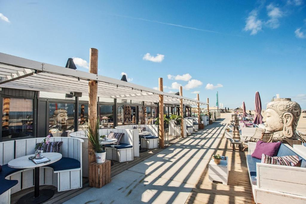a row of tables and chairs on a patio at Casa Vista Duna - Kijkduin in The Hague