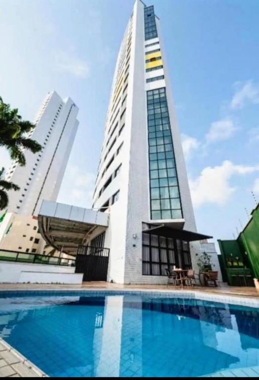 a building with a swimming pool in front of a building at Um lar aconchegante na rota do sol in Natal