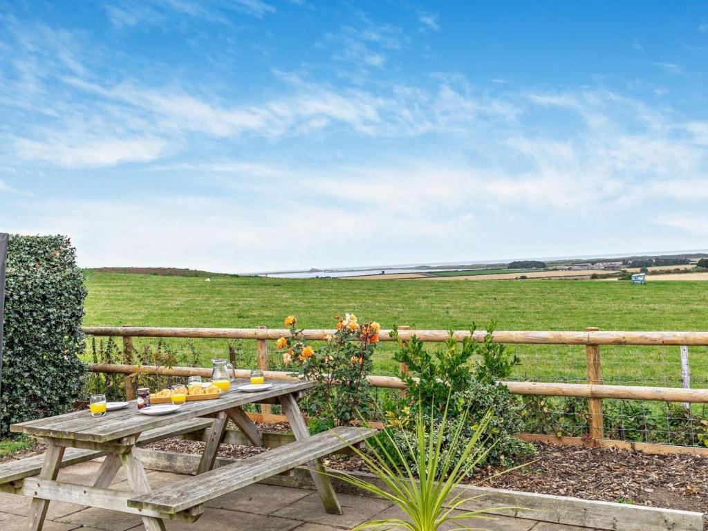 a wooden picnic table in front of a fence at 3 Bed in Belford oc-cn022 in Smeafield