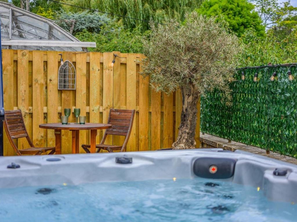 a hot tub in a backyard with a table and a tree at 2 Bed in Fordingbridge oc-96127 in Godshill