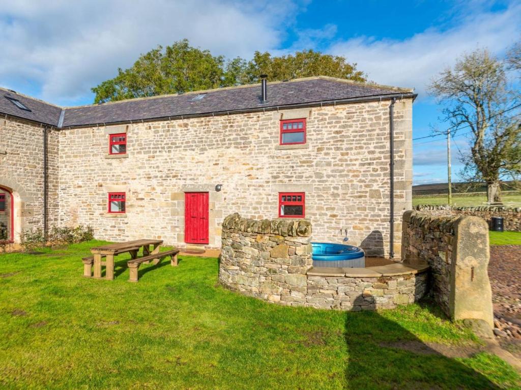a brick building with a fire pit and a picnic table at 4 Bed in Hexham oc-78159 in Catton