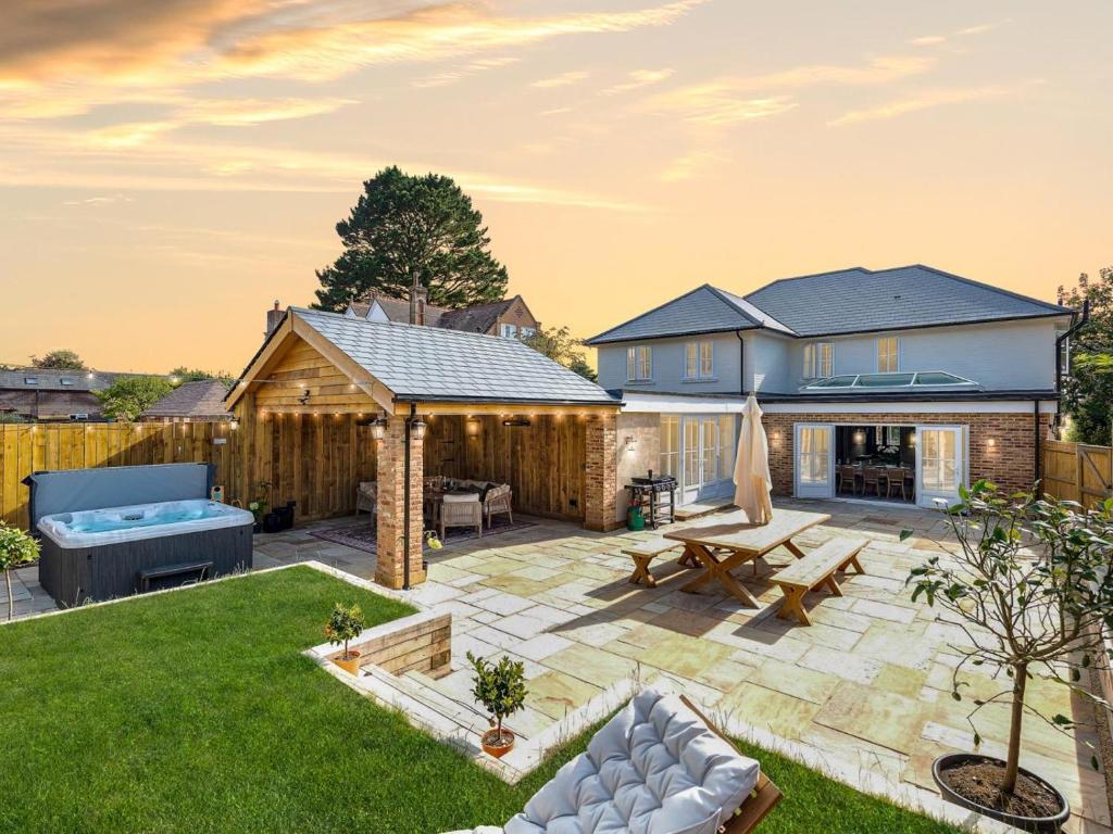 a backyard with a stone patio and a house at 5 Bed in Lymington oc-96189 in Sway