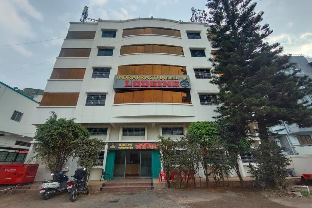 a large white building with a sign on it at Indraprastha Executive Lodging in Pune