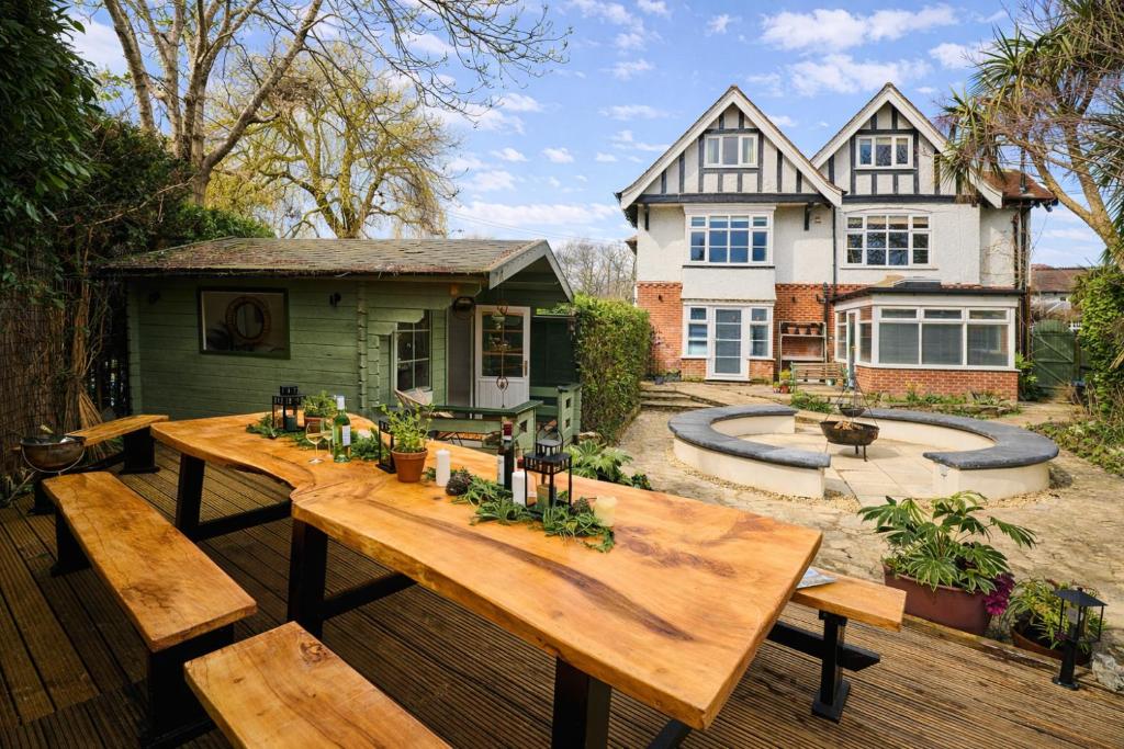 a backyard with a wooden table and benches at Little Hayes, Lyndhurst in Lyndhurst