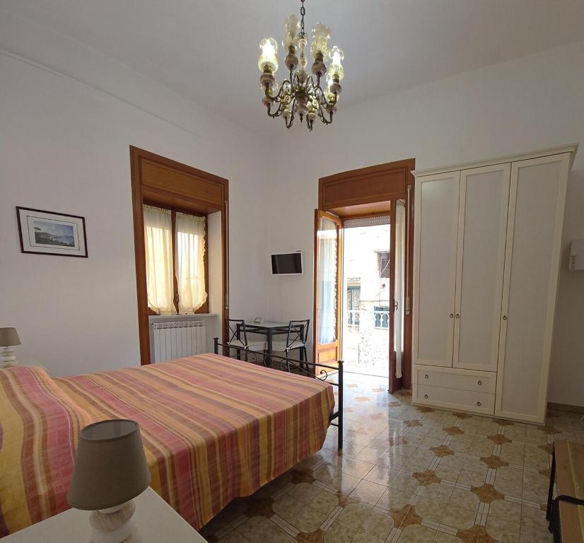 a bedroom with a bed and a chandelier at Rosa Dei Venti in Amalfi