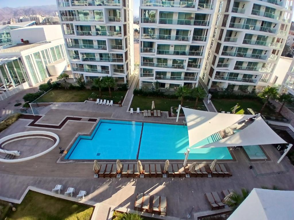 an overhead view of a swimming pool in front of tall buildings at Amor Club Luxury Suite in Eilat