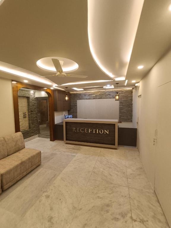 a lobby with a reception desk and a couch at Hotel High Rise in Kolkata