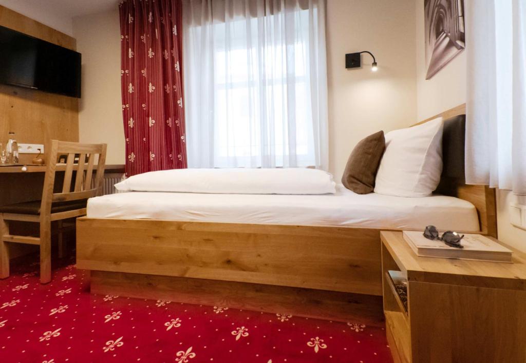 a bedroom with a bed with a window and a desk at Einzelzimmer 15 in Heidenheim