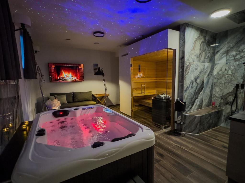 a large bathroom with a tub with a fireplace at Day SPA Design Muhr in Wehlenberg