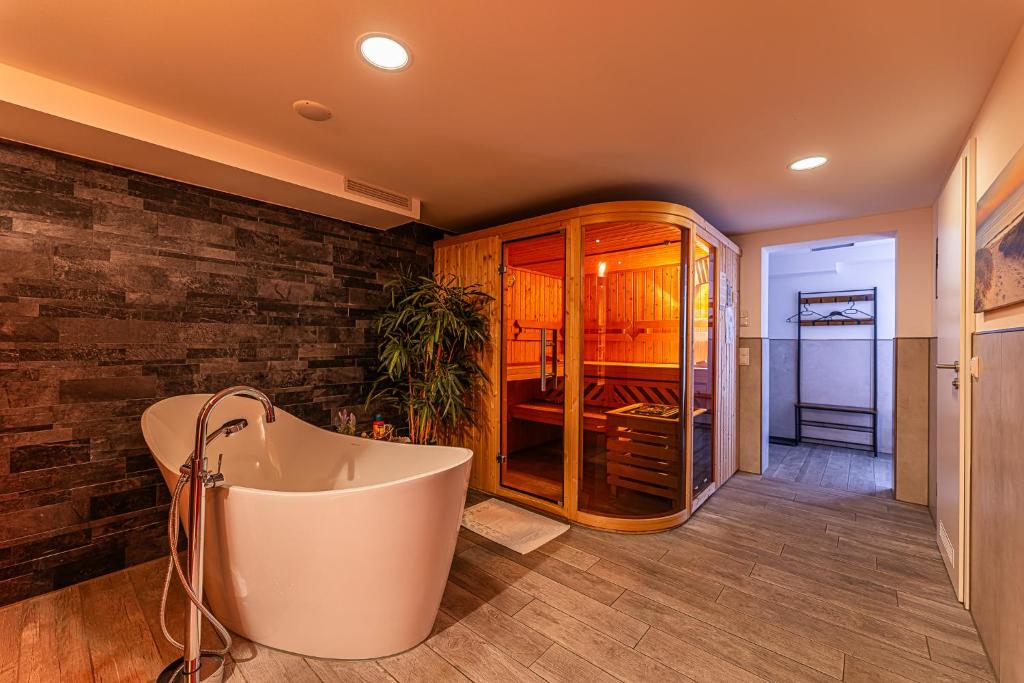 a bath tub in a bathroom with a brick wall at Day SPA Streudorf in Muhr amSee