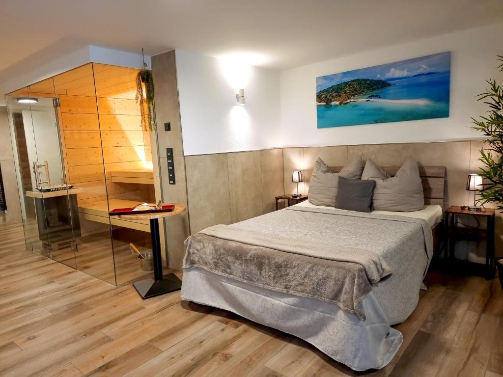 a bedroom with a large bed and a bathroom at Wellness Suite - Dream SPA in Spalt