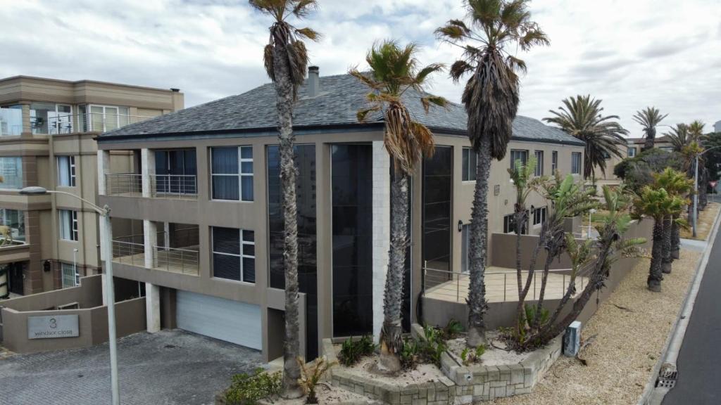 a house with palm trees in front of it at De Ocean Lane Guest House in Cape Town