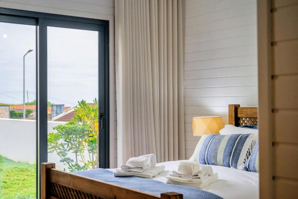 a bedroom with a bed and a large window at GuestReady - Good Vibes in Ponta Delgada