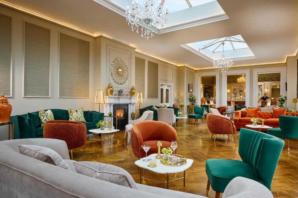 a lobby with couches and chairs and a fireplace at Cork's Vienna Woods Hotel & Villas in Cork
