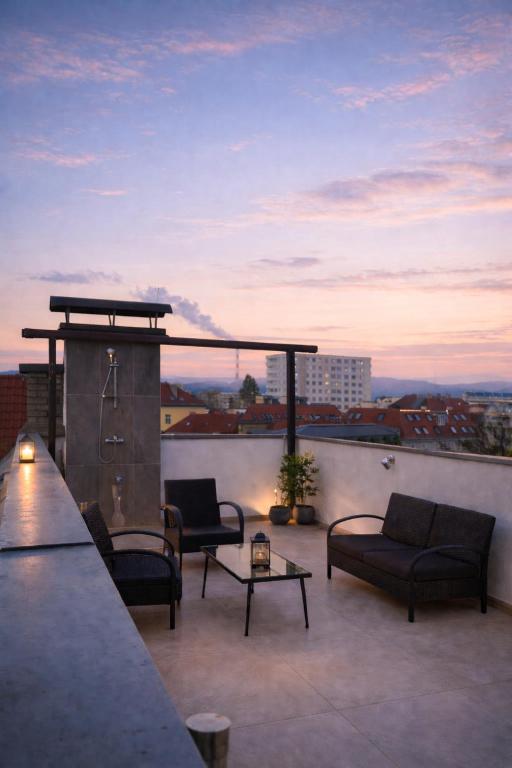 a patio with couches and chairs on a roof at Stadthotel Carinthia in Klagenfurt