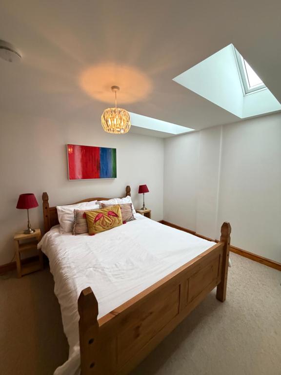 a bedroom with a large bed with a skylight at Flat 2, Coneygre Farm in Hoveringham