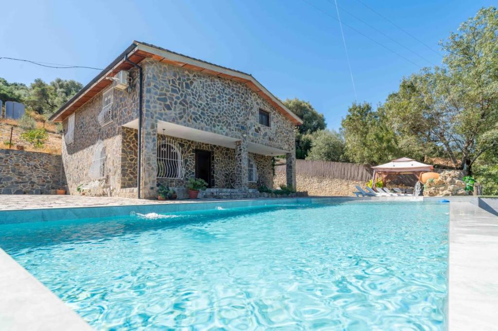 a house with a swimming pool in front of a building at El Acebuchal de Ubrique in Ubrique