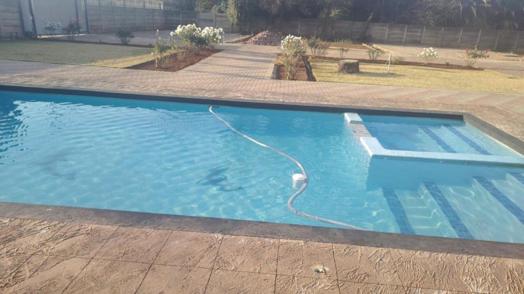 a swimming pool with a hose in the water at Self catering apartment in Vereeniging