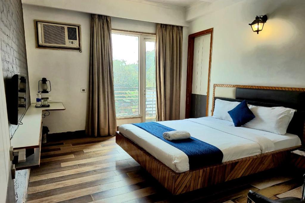 a bedroom with a bed and a large window at Premium Nest, Golf Course Road in Gurgaon
