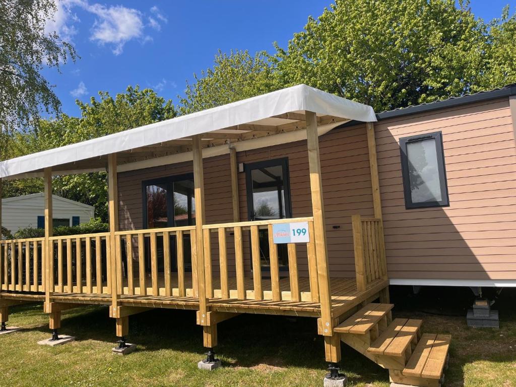 a tiny house with a porch and awning at Camping Le Walric in Saint-Valéry-sur-Somme