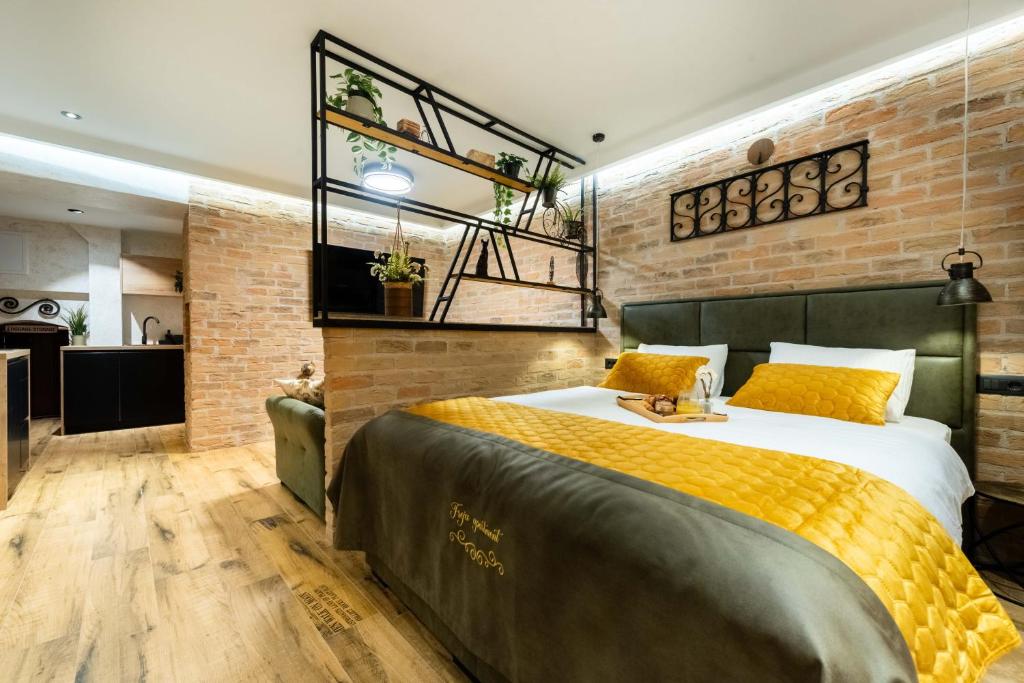 a bedroom with a bed and a brick wall at Deluxe Dino room & studio apartment by Adex travel in Zadar