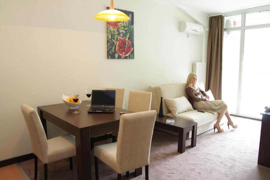 a woman sitting on a couch in a living room at Hotel Royal Spa in Banja Koviljača