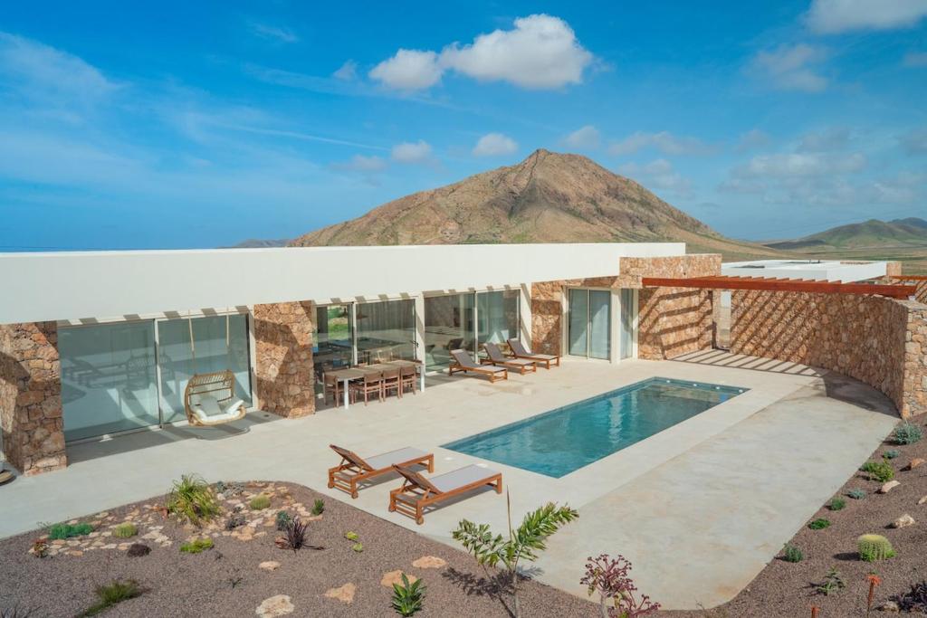 a house with a swimming pool and a mountain at Villa Gypsy by Aura Collection in Tindaya