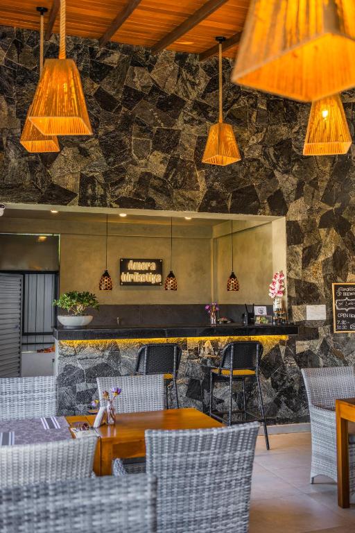 a restaurant with a table and chairs and a stone wall at Amera Hiriketiya in Dickwella