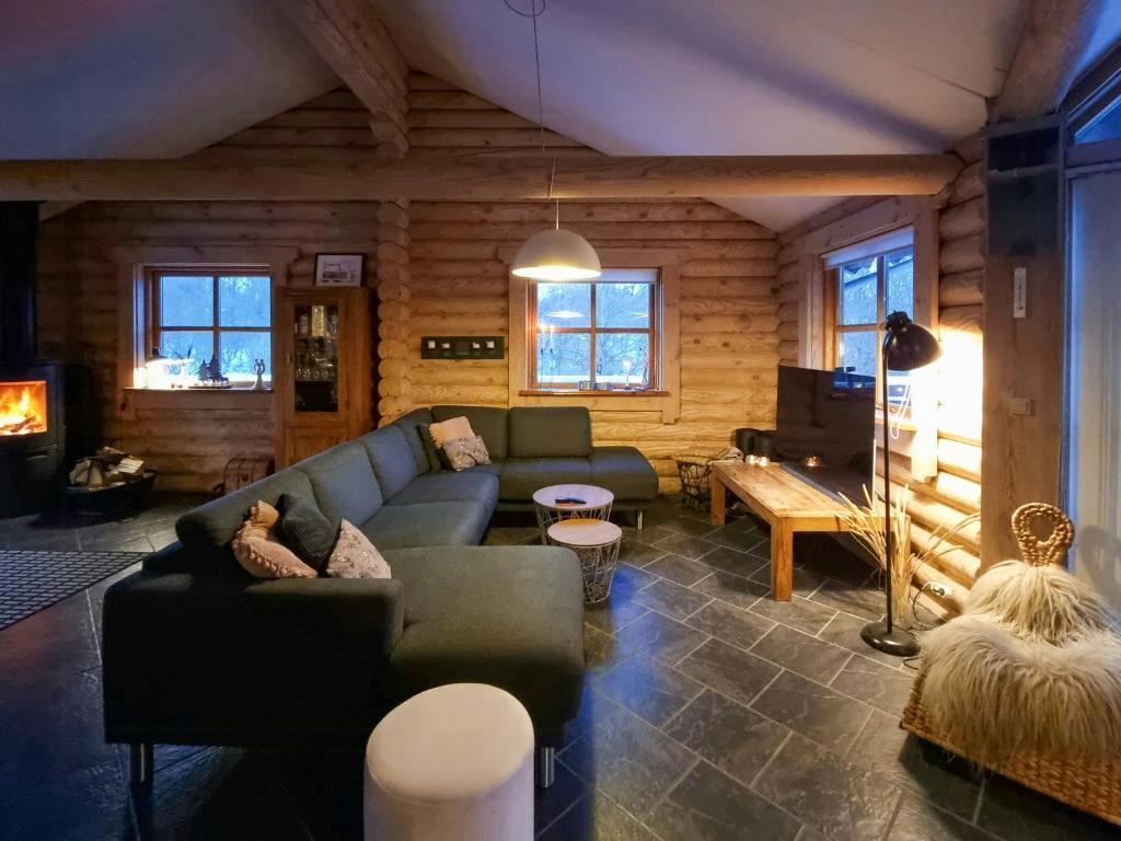 a living room with a couch and a piano at Round Timber House In Forest Near Mariager in Hadsund