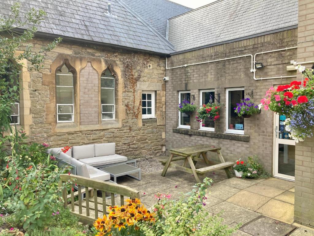 a patio with a bench and a table in front of a building at Ludlow Mascall Centre in Ludlow