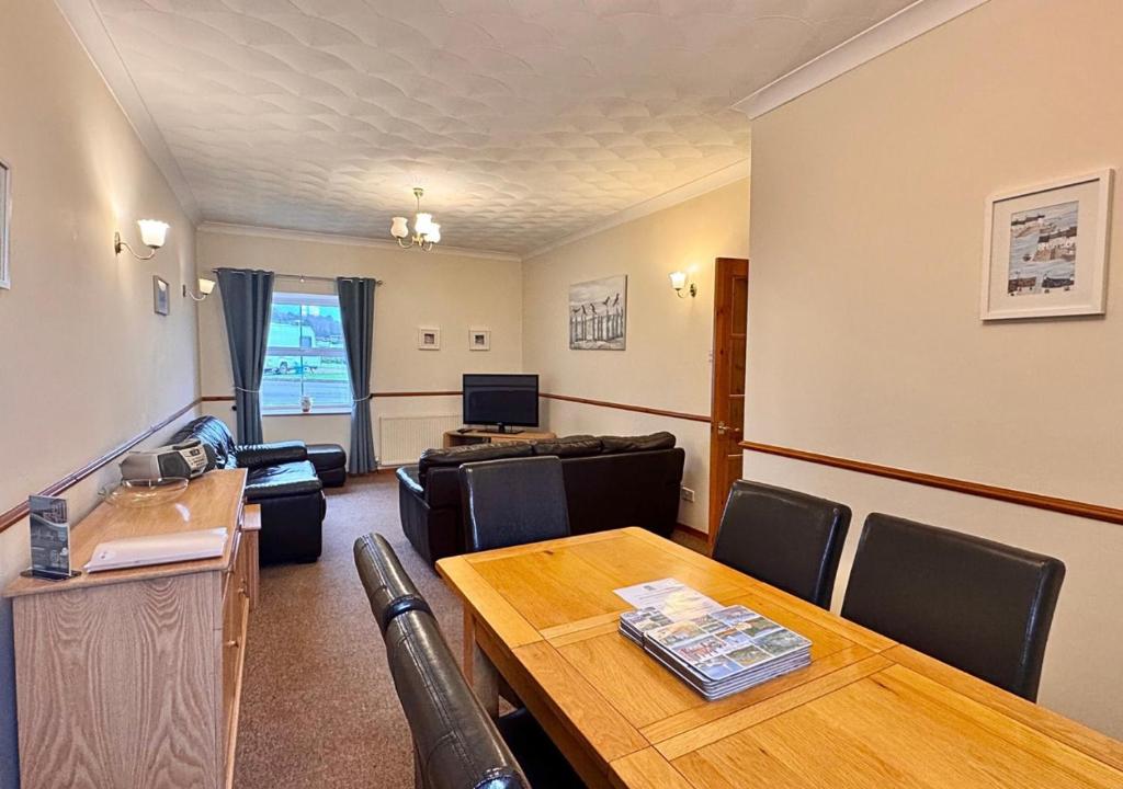 a conference room with a table and chairs and a couch at Seacrest Cottage in Conwy