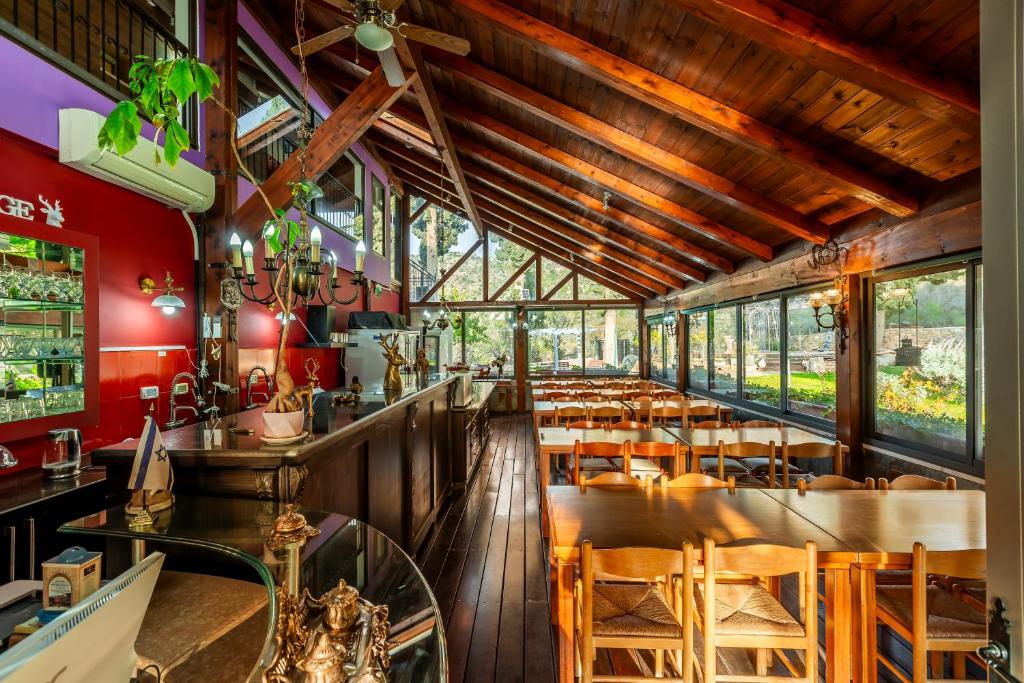 a restaurant with wooden ceilings and tables and chairs at Jacob Ha-Tzayadim in Geʼullim