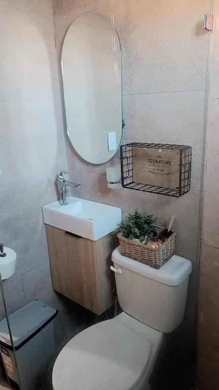 a bathroom with a toilet and a sink and a mirror at El descanso in Higuey