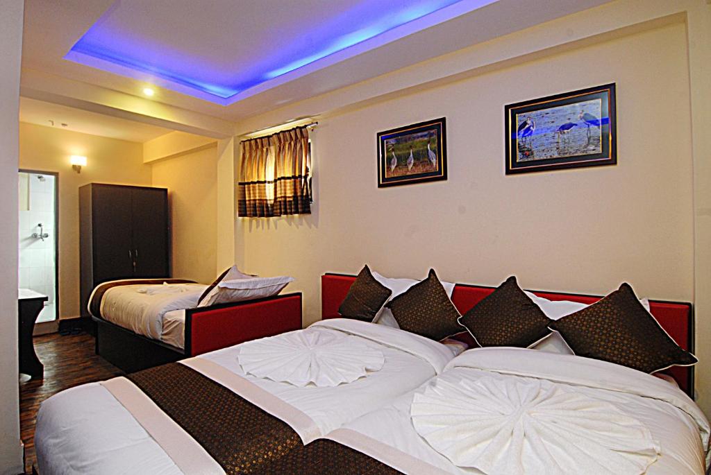 Habitación de hotel con 2 camas y techo azul en Hotel Gallery Nepal, en Katmandú