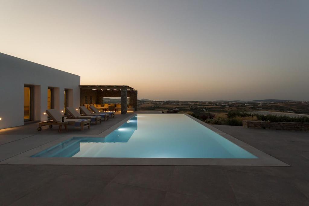 a swimming pool on the side of a house at Villa Anelya in Parikia