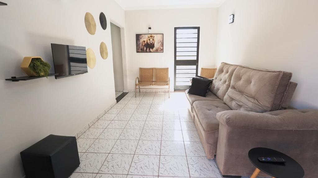 a living room with a couch and a tv at Jahu Center Lodge in Jaú