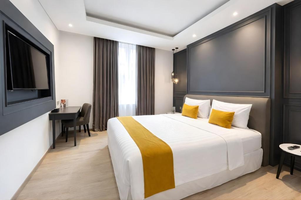 a hotel room with a bed and a desk at Hotel Shalva Jakarta in Jakarta