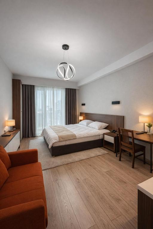 a large bedroom with a large bed and a desk at Relax Apartments in Crystal Residence Bakuriani in Bakuriani