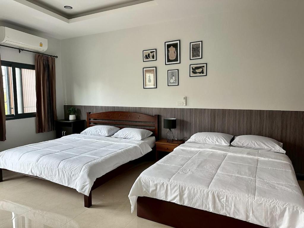 two beds in a room with two beds sidx sidx sidx sidx at Cocoon Casa in Hat Yai