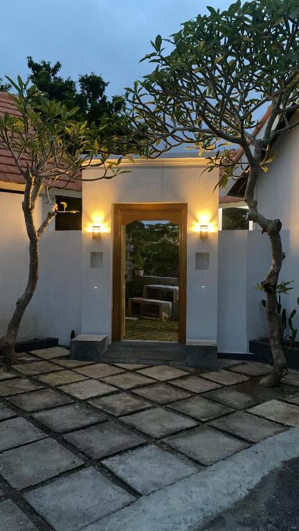 two trees in front of a building with a door at my house guest house in batumadeg