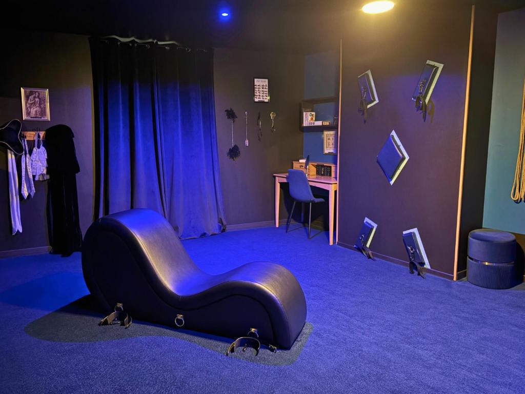 a room with a leather chair in a room with a desk at Suite Casanova avec SPA & Escape Love Game - Doux Bleu Jeux in Niort