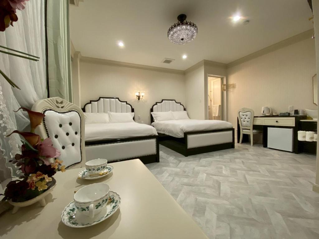 a hotel room with two beds and a table with dishes at 大同GardenHotel 大阪西九条Annex in Osaka