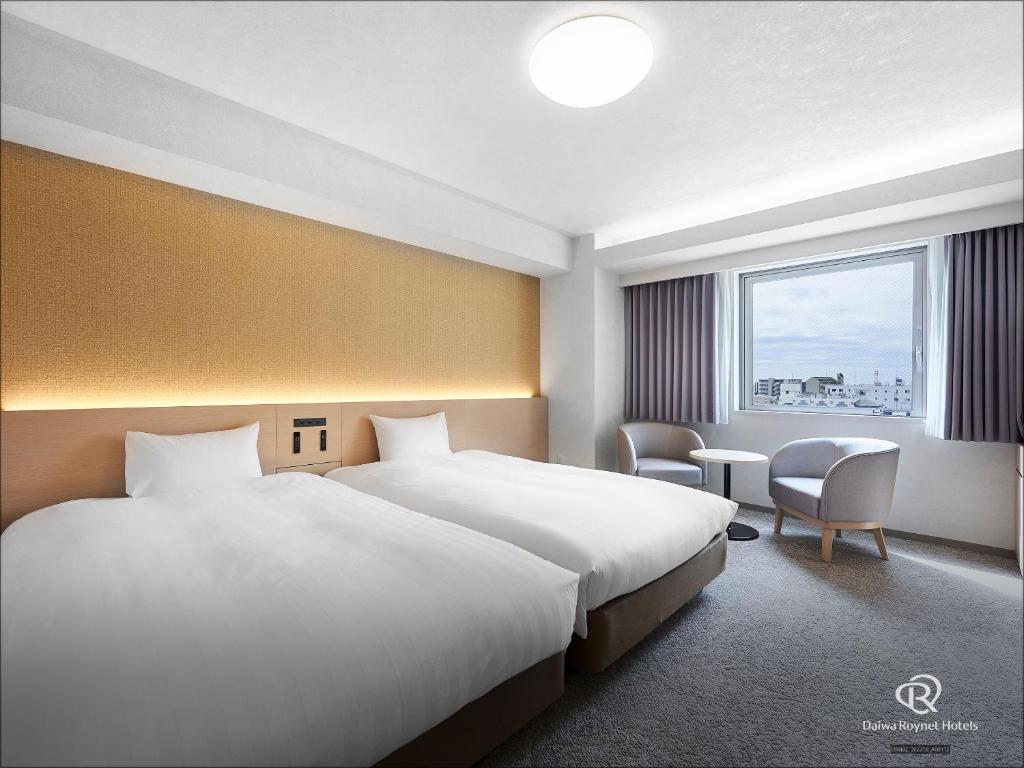 a hotel room with two beds and a window at Daiwa Roynet Hotel Kawasaki in Kawasaki