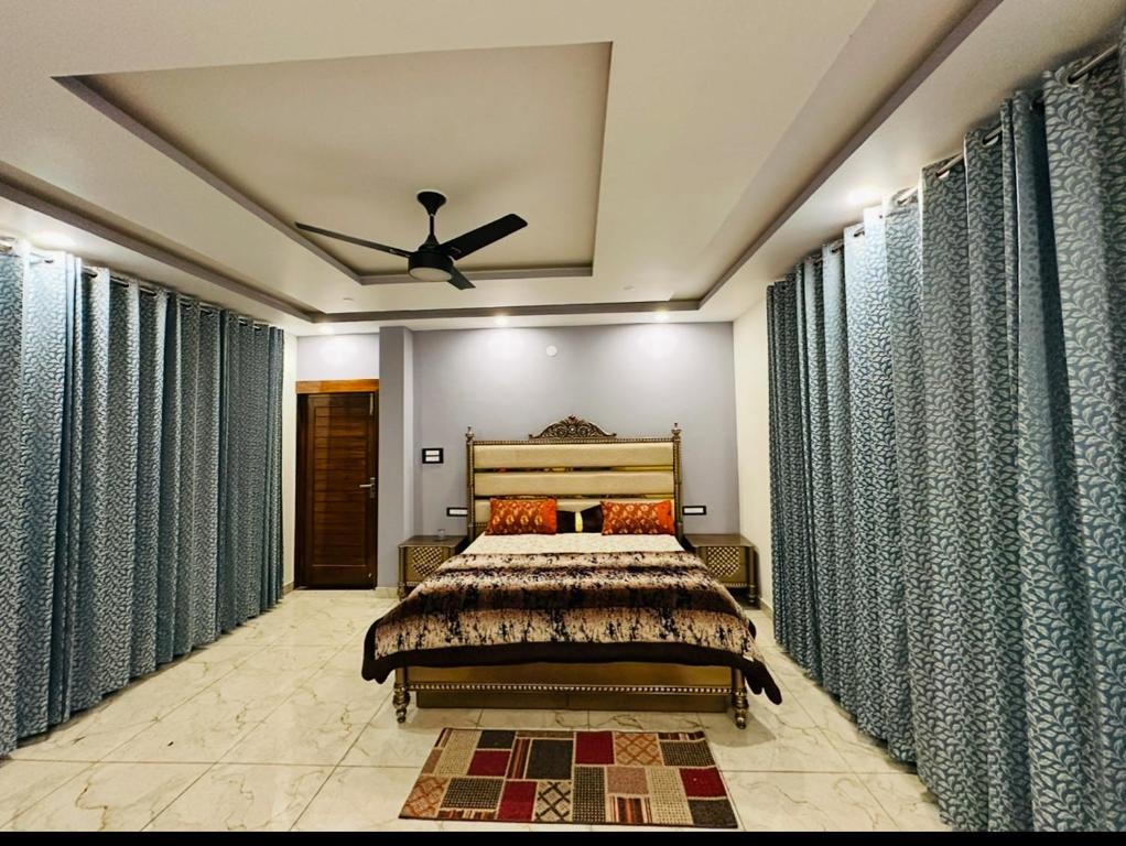 a bedroom with a bed and a ceiling fan at Dhauladhar Vista in Pālampur