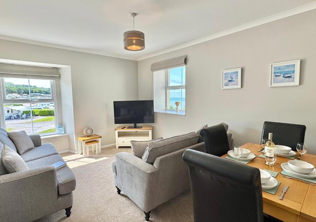 a living room with a couch and a table at Sunset Cottage in Llanddulas